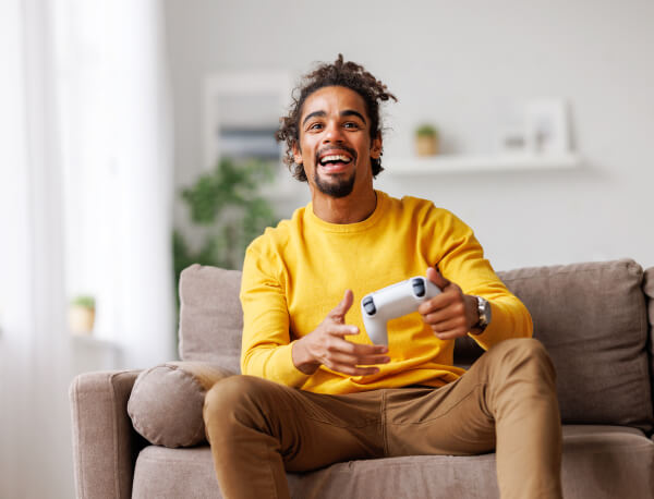 Man Sitting On Couch Holding Video Gaming Controller