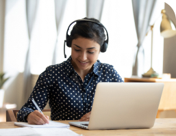 Woman Wearing Headphones Working At Laptop